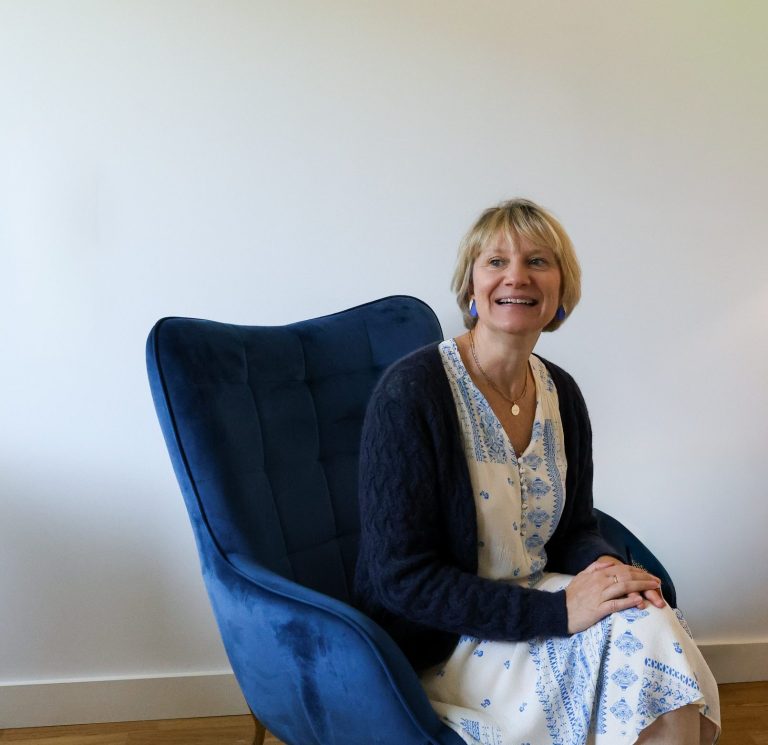 Magali Verkindere installée dans son fauteuil, prête à recevoir et écouter son client pour une thérapie, un accompagnement burn-out ou un bilan de compétences